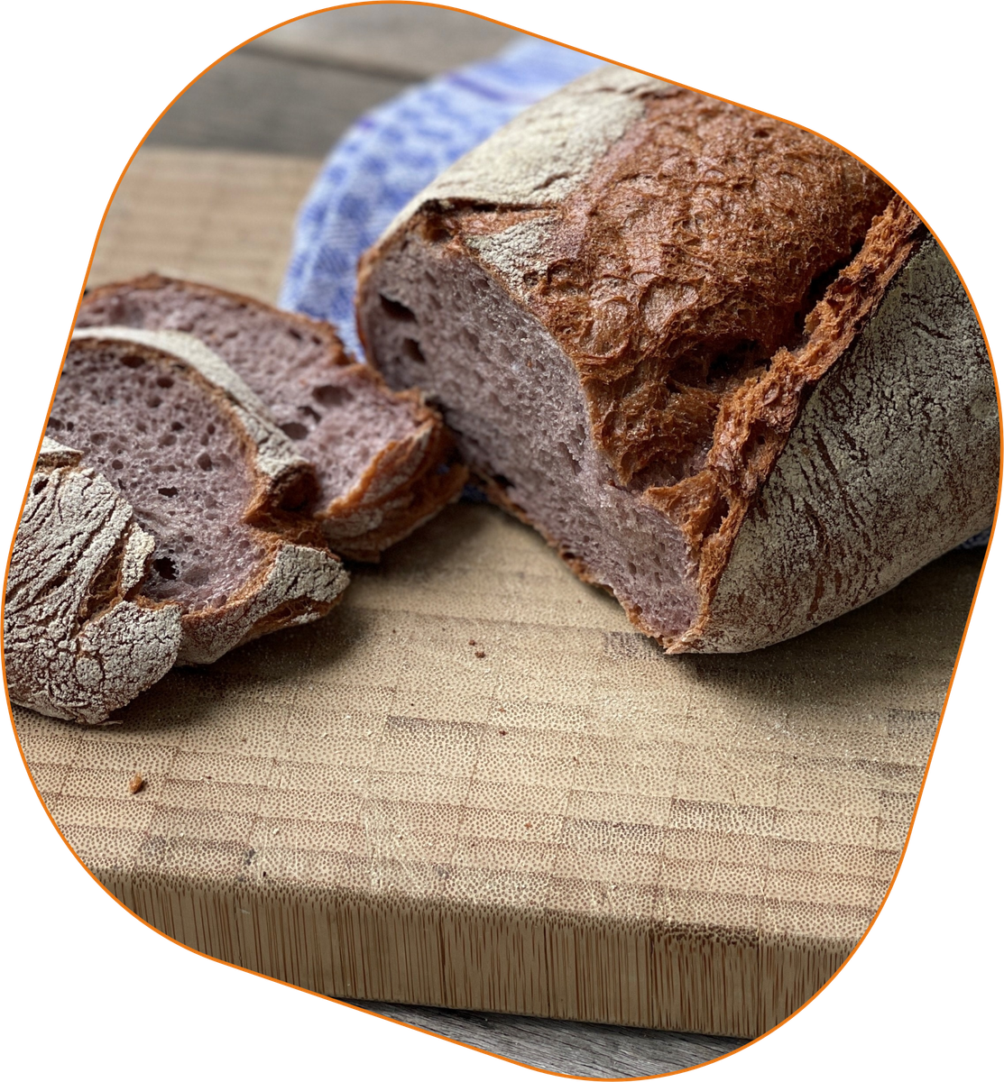 KI generiert: Das Bild zeigt ein aufgeschnittenes Brot auf einem Holzbrett, begleitet von einem blauen Tuch im Hintergrund. Der Schwerpunkt liegt auf der knusprigen Kruste und der Textur des Brotes.
