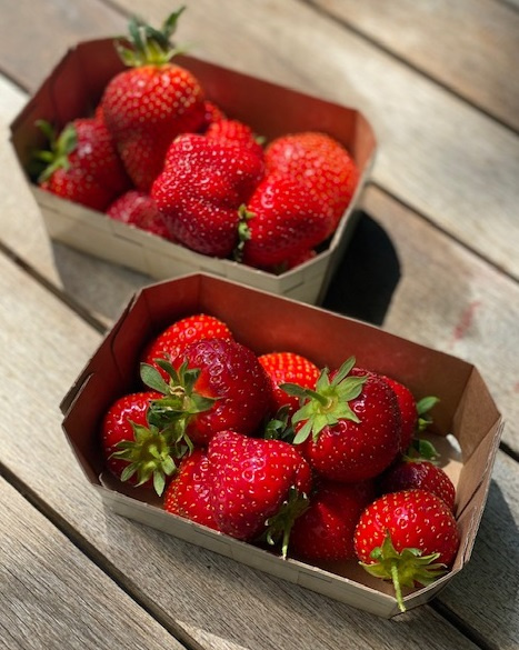 KI generiert: Zwei Schalen mit frischen roten Erdbeeren auf einem Holztisch.
