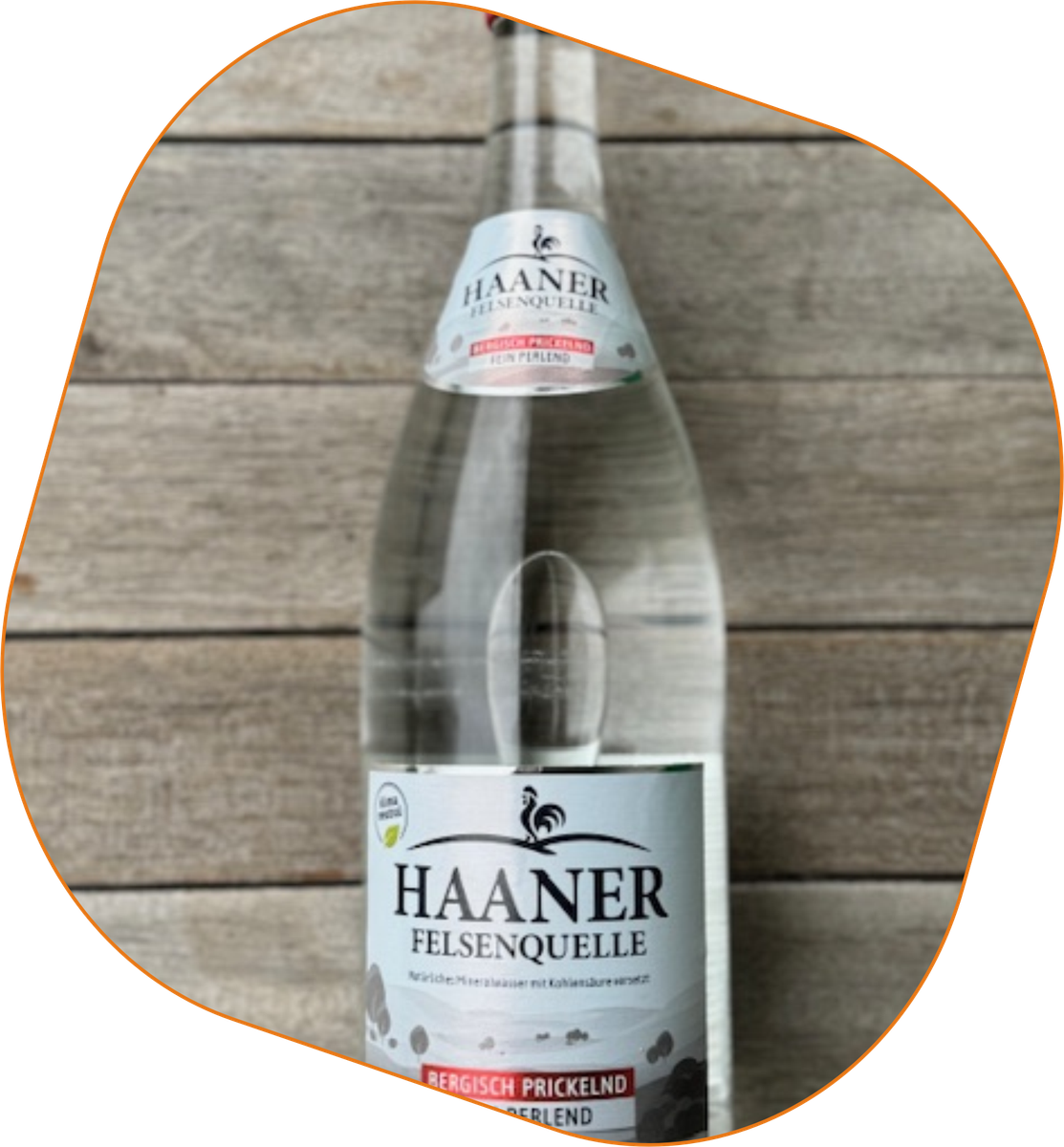 KI generiert: Das Bild zeigt eine Flasche Haaner Felsenquelle Mineralwasser auf einer Holzoberfläche. Die Flasche enthält kohlensäurehaltiges Wasser und ist klar etikettiert.